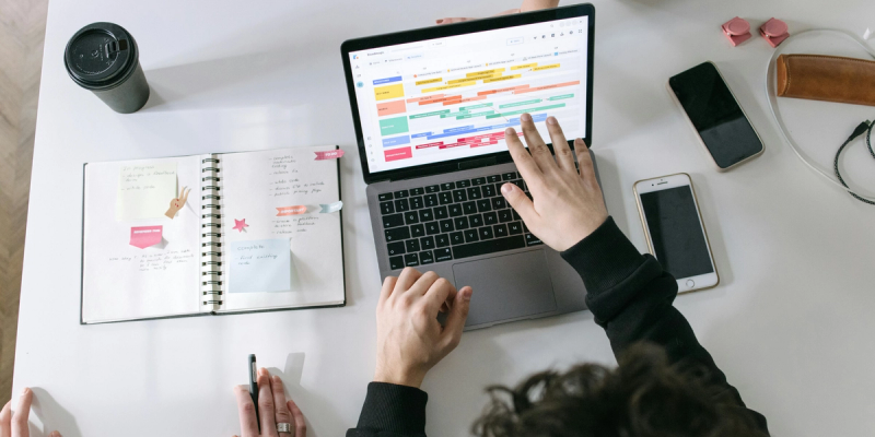 Person in front of a Mac computer with a Google Calendar schedule on the screen